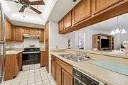 Clearwater apartment for rent - A kitchen with wooden cabinets and a tile floor at Hampton Apartments, Clearwater, FL