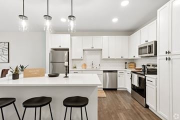 Deforest apartment for rent - A kitchen with white cabinets and black stools.