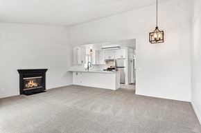 Santa Rosa apartment for rent - A living room with a fireplace and a kitchen in the background.