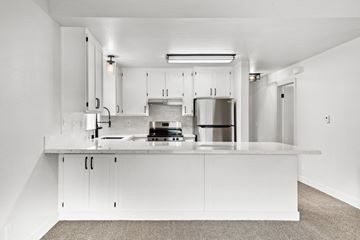 Santa Rosa apartment for rent - A modern kitchen with white cabinets and stainless steel appliances.