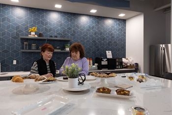 Two women sitting at a table with food