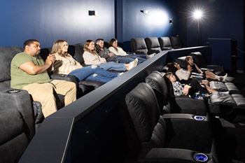 A large group of people sitting in a darkened movie theater