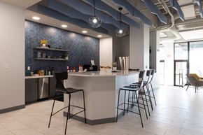 Saint Louis apartment for rent - a kitchen with a counter and chairs in a lobby at The Residences at Tesson Ridge, Saint Louis, MO, 63128