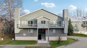 Anchorage apartment for rent - A grey two-story apartment building with a balcony on the second floor.