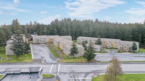 Kodiak apartment for rent - A large building complex with a parking lot in front.