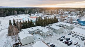 North Pole apartment for rent - A snowy landscape with a building and cars.