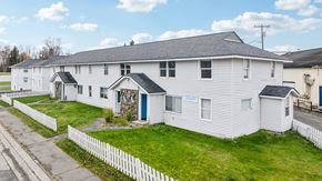 Anchorage apartment for rent - A white building with a blue door and a sign on the window.