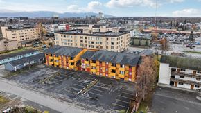 Anchorage apartment for rent - A parking lot in front of a large building with orange and black stripes.