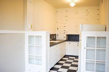 Portland apartment for rent - A kitchen with white cabinets and a black and white checkered floor.