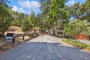 Paso Robles apartment for rent - A gravel road leads to a sign on the left and a fence on the right.