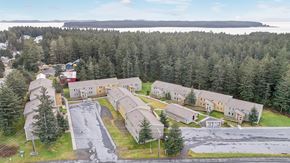 Kodiak apartment for rent - A large building complex surrounded by trees.
