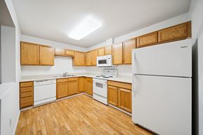 Anchorage apartment for rent - A kitchen with wooden cabinets and white appliances.