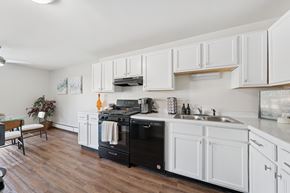Naperville apartment for rent - A kitchen with white cabinets and a black dishwasher.
