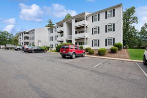 Charlottesville apartment for rent - Parking lot in front of a white apartment building.