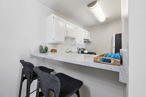 Odenton apartment for rent - A kitchen with white cabinets and a counter with a basket of blue cloths on it.