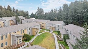 Kodiak apartment for rent - A view of a housing complex with a green lawn in the foreground.