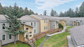 Kodiak apartment for rent - A view of apartment buildings with a tree in the foreground.