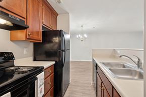 Charlottesville apartment for rent - A kitchen with black appliances and wooden cabinets.