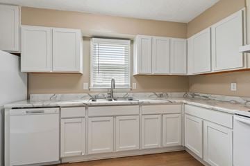 Charlotte apartment for rent - A kitchen with white cabinets and a marble countertop.