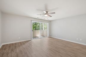 Charlottesville apartment for rent - A room with a ceiling fan and sliding glass doors.