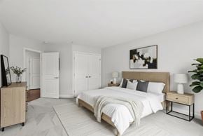 Bloomfield apartment for rent - A bedroom with a large bed, a wooden nightstand, and a painting on the wall.