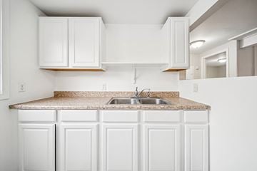 Anchorage apartment for rent - A kitchen with white cabinets and a granite countertop.