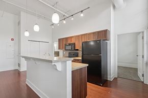 Pittsburgh apartment for rent - A kitchen with a black refrigerator and wooden cabinets.
