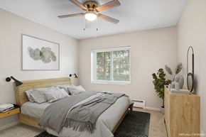 Minneapolis apartment for rent - A bedroom with a bed, a ceiling fan, and a nightstand.