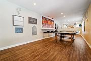 Riverside apartment for rent - a game room with a ping pong table and paintings on the wall