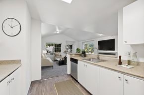 Beaverton apartment for rent - A kitchen with white cabinets and a clock on the wall.