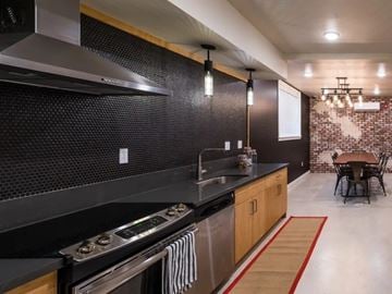 Portland apartment for rent - A modern kitchen with a stove top oven and a black counter top.