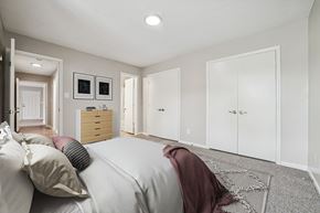 Charlotte apartment for rent - A bedroom with a bed, a dresser, and a wardrobe.