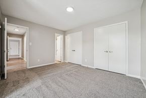 Charlotte apartment for rent - A spacious room with white doors and carpeted floor.