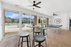 Naperville apartment for rent - A room with a pool outside the window and a table with chairs.