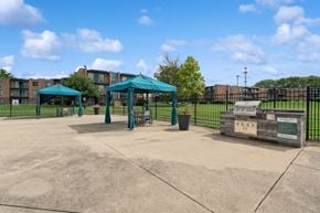 Naperville apartment for rent - A playground with a green canopy and a sign on a wooden post.
