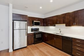 Pittsburgh apartment for rent - A kitchen with dark wood cabinets and a white counter top.