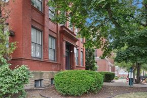Pittsburgh apartment for rent - A red brick building with a green bush in front.