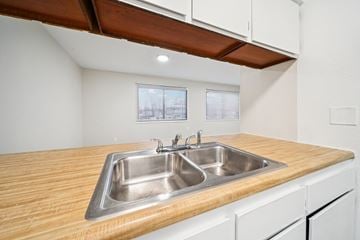 Anchorage apartment for rent - A kitchen with a double sink and wooden countertop.