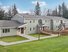 Homer apartment for rent - A row of houses with a green lawn in front.