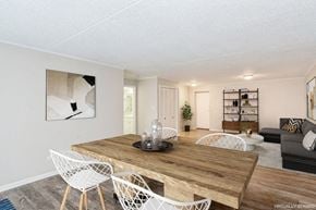 Pittsburgh apartment for rent - A living and dining room with a sectional sofa, wooden table, and white chairs.