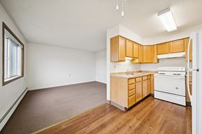 Kenai apartment for rent - A kitchen with wooden cabinets and a white fridge.