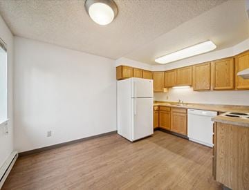 Homer apartment for rent - A kitchen with wooden cabinets and a white refrigerator.
