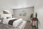 Pittsburgh apartment for rent - A bedroom with a large bed and a desk with a plant on it.