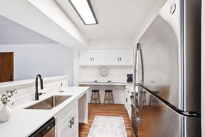 Wayzata apartment for rent - A modern kitchen with white cabinets and a stainless steel refrigerator.