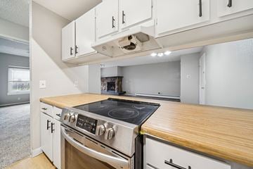 Anchorage apartment for rent - A modern kitchen with a stove top oven and white cabinets.