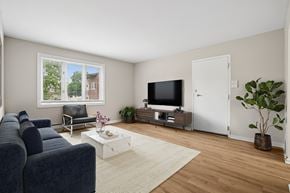 North Aurora apartment for rent - A living room with a blue couch, a white coffee table, and a flat screen TV.