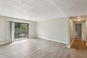 Pittsburgh apartment for rent - A spacious room with wooden flooring and a sliding glass door leading to a patio.