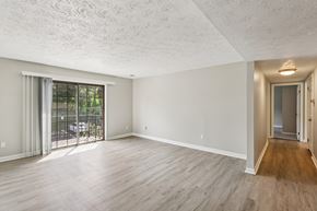 Pittsburgh apartment for rent - A spacious room with wooden flooring and a sliding glass door leading to a patio.