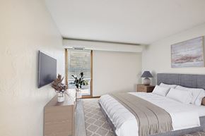 Wayzata apartment for rent - A bedroom with a large bed and a television on the wall.
