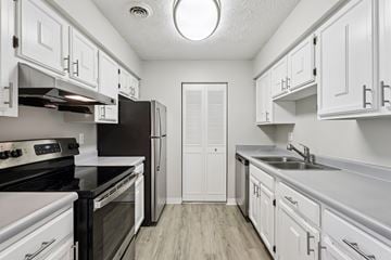 Pittsburgh apartment for rent - A kitchen with white cabinets and black countertops.